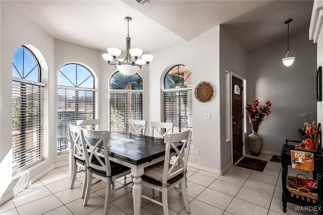 dining space with an inviting chandelier, light tile patterned floors, and baseboards