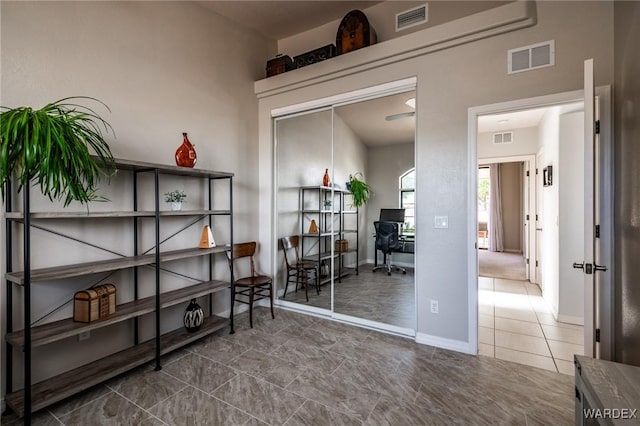 living area with baseboards and visible vents