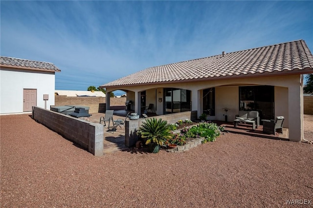 rear view of property with outdoor lounge area, a patio area, a tile roof, and stucco siding