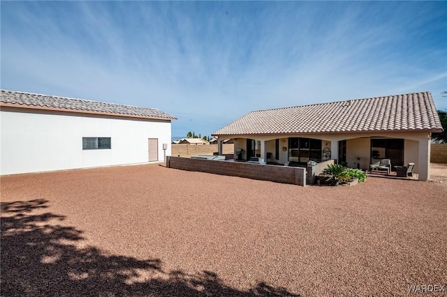 back of house with a patio, a tiled roof, and stucco siding