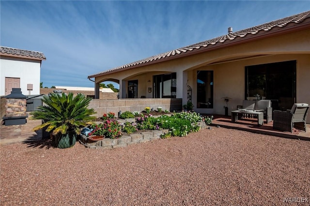 rear view of house with an outdoor hangout area, fence, a tiled roof, and stucco siding