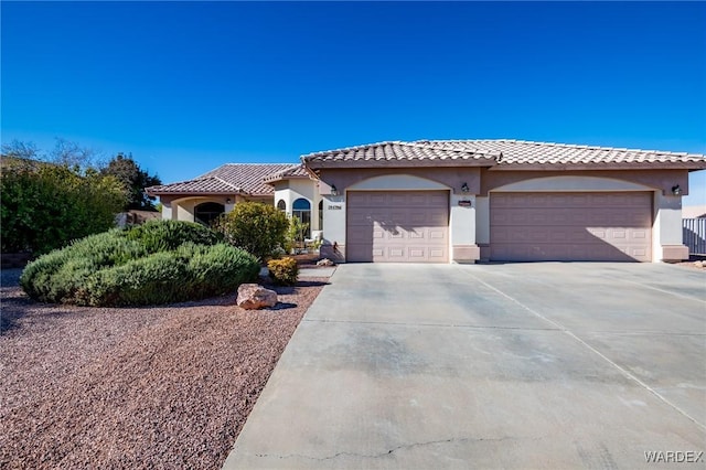 view of front of property with driveway, an attached garage, a tile roof, and stucco siding