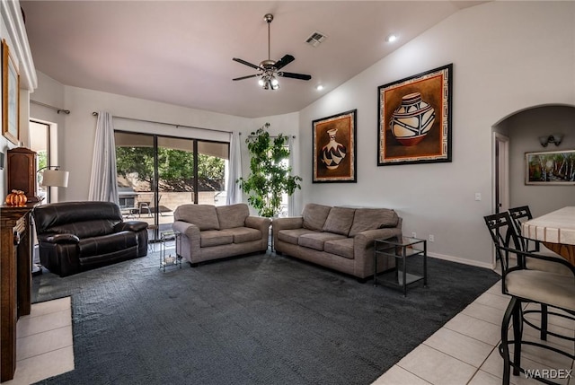 living room with arched walkways, light tile patterned floors, lofted ceiling, visible vents, and a ceiling fan