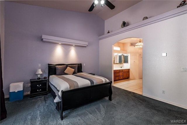 bedroom featuring light carpet, light tile patterned floors, arched walkways, lofted ceiling, and a sink