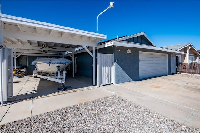 view of front facade featuring stucco siding, concrete driveway, board and batten siding, ceiling fan, and a carport