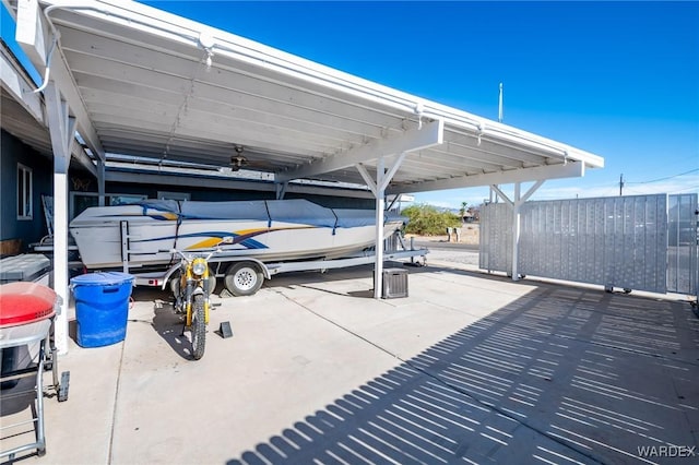 view of parking / parking lot with a carport and fence