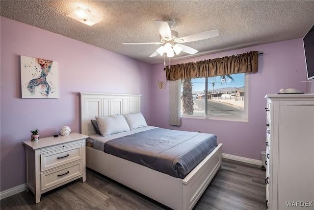 bedroom featuring dark wood-style floors, ceiling fan, a textured ceiling, and baseboards