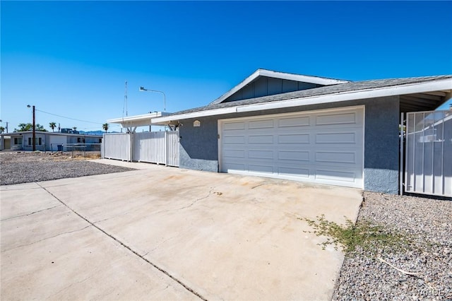 garage with driveway and fence