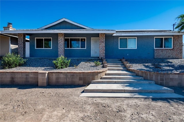 ranch-style home featuring brick siding, board and batten siding, and stucco siding