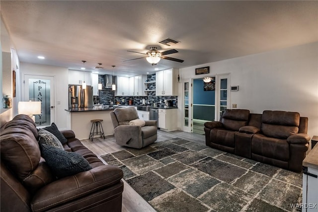 living area with ceiling fan, visible vents, dark wood-style flooring, and recessed lighting