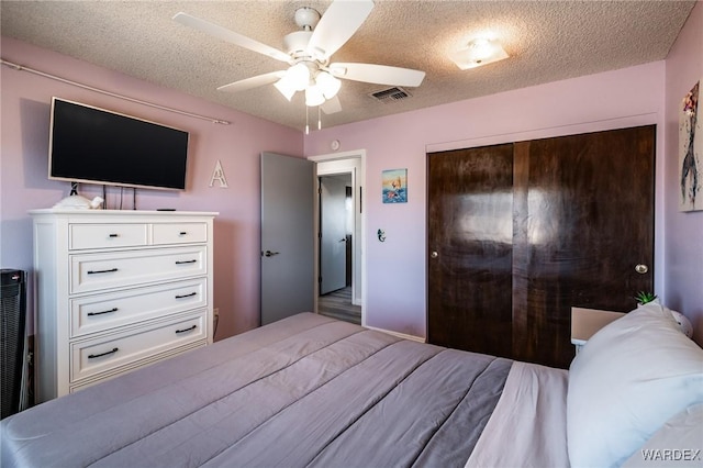 bedroom with ceiling fan, a closet, visible vents, and a textured ceiling