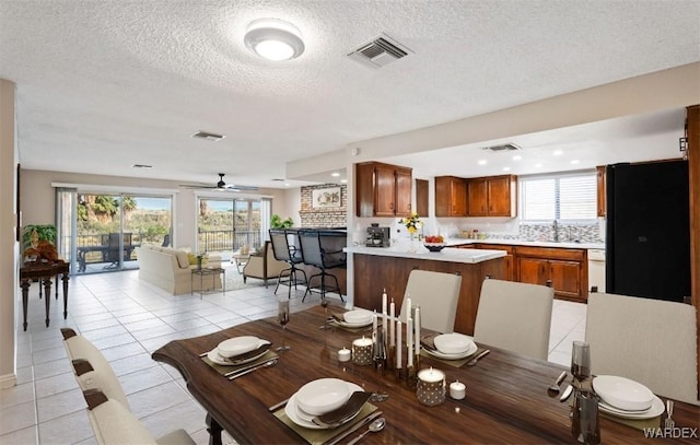 dining area featuring light tile patterned floors, visible vents, and a healthy amount of sunlight