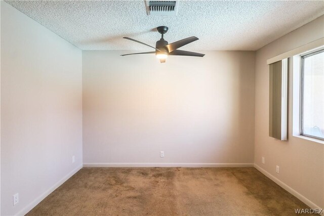 unfurnished room with ceiling fan, a textured ceiling, carpet floors, visible vents, and baseboards