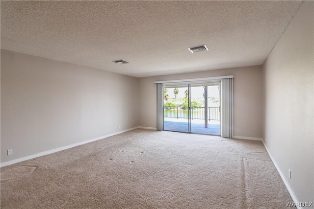 unfurnished room with baseboards, visible vents, and light colored carpet