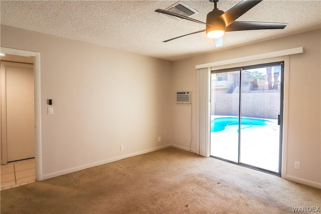 empty room featuring a wall mounted AC, light carpet, ceiling fan, a textured ceiling, and baseboards