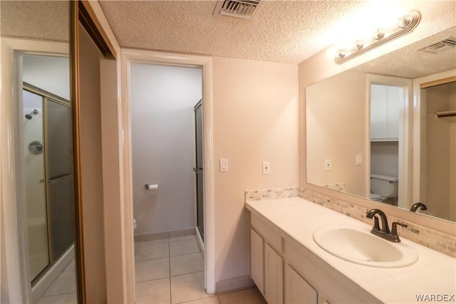 full bathroom with visible vents, a textured ceiling, a shower stall, and toilet