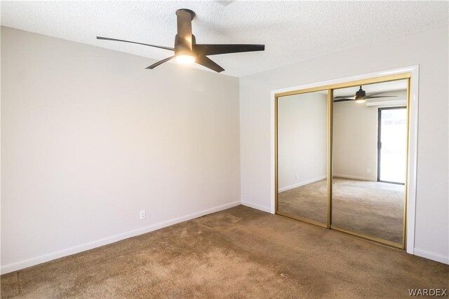 unfurnished bedroom with a textured ceiling, a ceiling fan, baseboards, a closet, and carpet