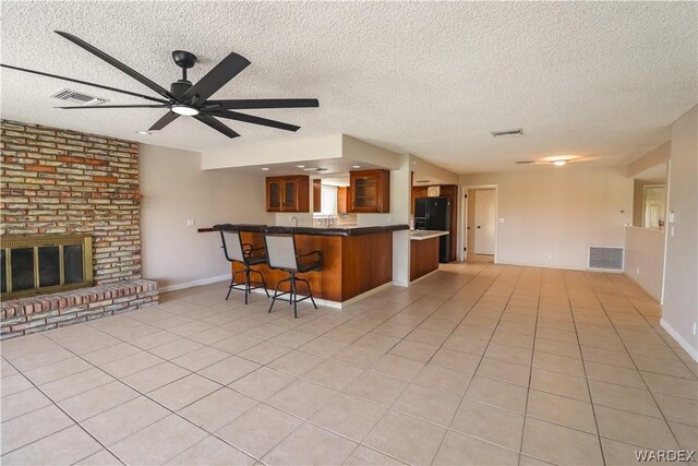 kitchen with a peninsula, glass insert cabinets, brown cabinets, and open floor plan