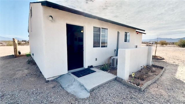 exterior space featuring a mountain view and stucco siding