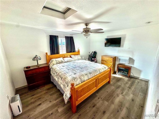 bedroom with dark wood finished floors, a textured ceiling, baseboards, and ceiling fan