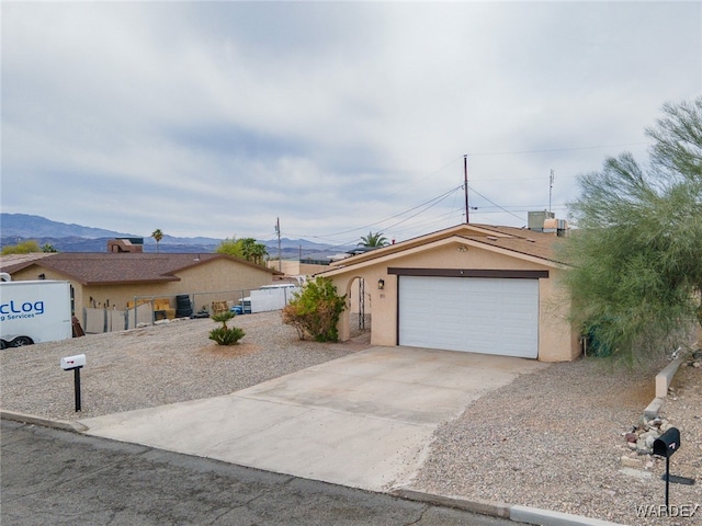 89 Keywester Dr, Lake Havasu, AZ 86403 - ranch-style house featuring a mountain view, fence, a garage, and stucco siding