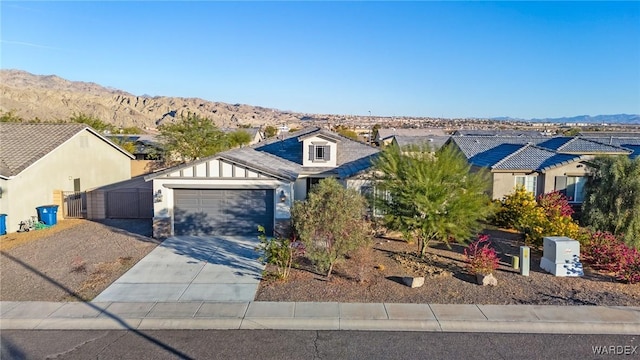 view of front of property with driveway, a residential view, an attached garage, a mountain view, and board and batten siding