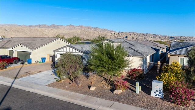 ranch-style house with a residential view, a mountain view, and stucco siding