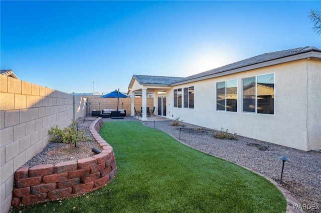 view of yard featuring a patio, outdoor lounge area, and a fenced backyard