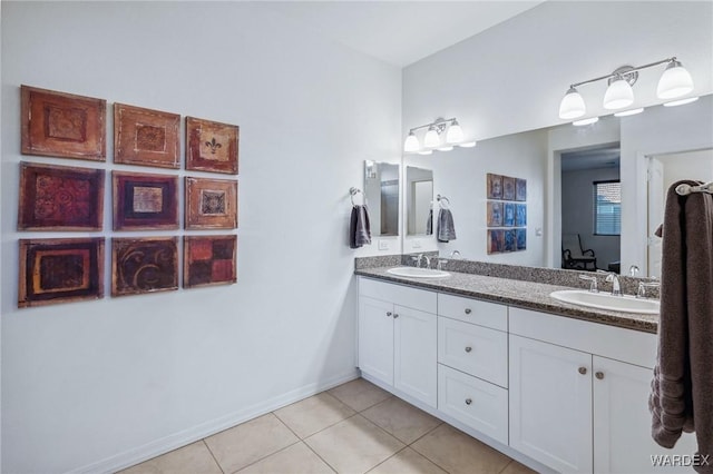 bathroom with tile patterned flooring, a sink, baseboards, and double vanity