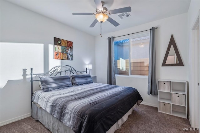 bedroom with baseboards, visible vents, dark colored carpet, and a ceiling fan