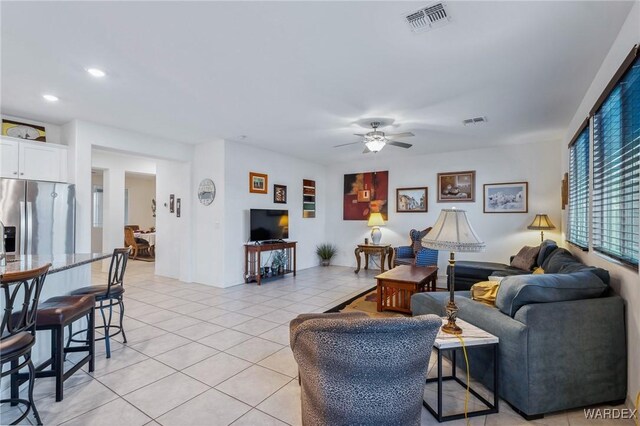 living room featuring light tile patterned floors, ceiling fan, visible vents, and recessed lighting