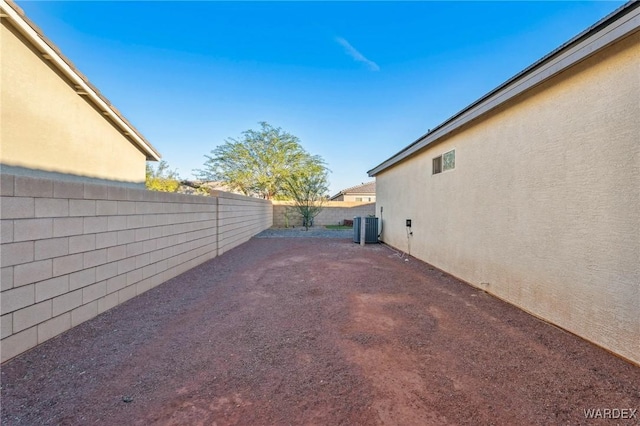 view of yard with a fenced backyard and central air condition unit