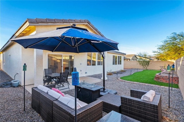 back of property with an outdoor hangout area, a patio area, a fenced backyard, and stucco siding