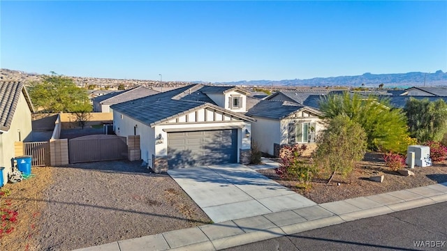 view of front of property with concrete driveway, an attached garage, a gate, a mountain view, and a residential view