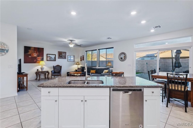 kitchen with a sink, white cabinetry, open floor plan, and stainless steel dishwasher