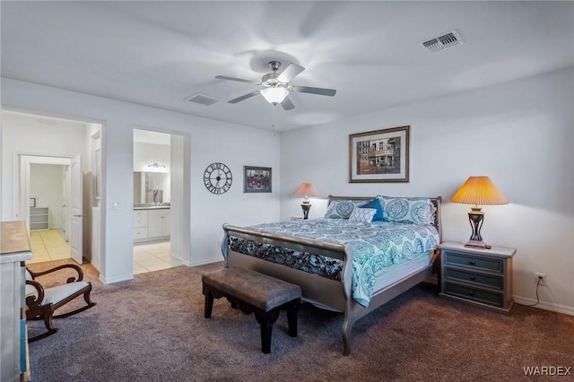 bedroom featuring ensuite bath, baseboards, visible vents, and light colored carpet