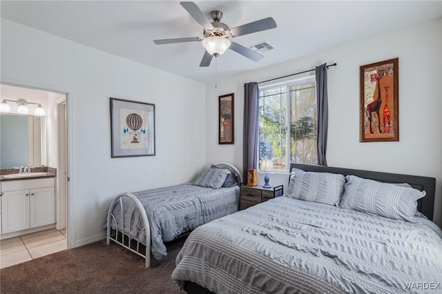 bedroom featuring ensuite bathroom, ceiling fan, light colored carpet, a sink, and visible vents