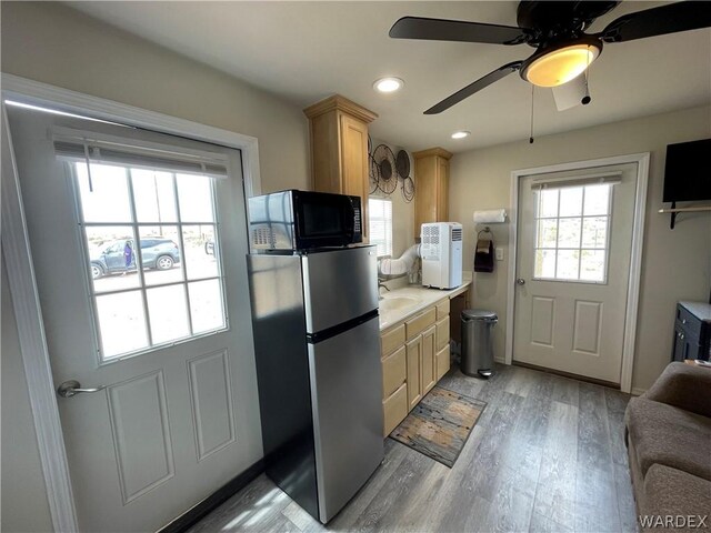 kitchen featuring freestanding refrigerator, light countertops, light wood-style flooring, and light brown cabinetry