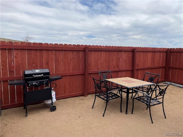 view of patio featuring outdoor dining area, grilling area, and fence