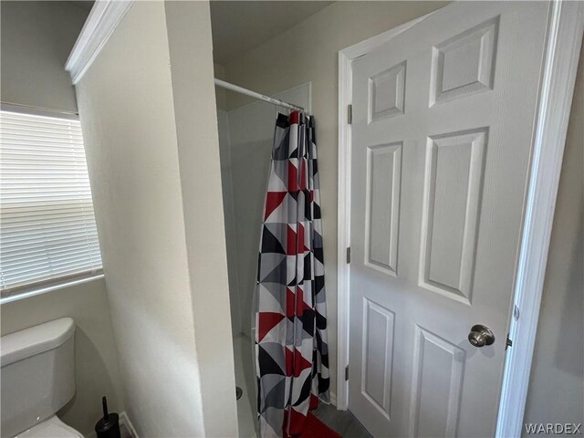 full bathroom with curtained shower and toilet