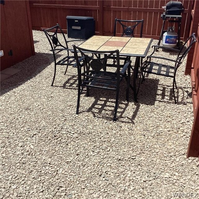 view of patio with outdoor dining space, a grill, and fence