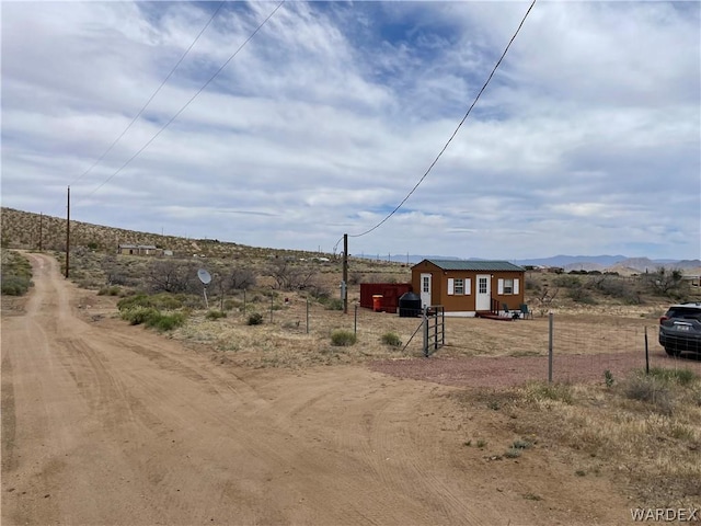 view of yard featuring fence, a mountain view, and a rural view