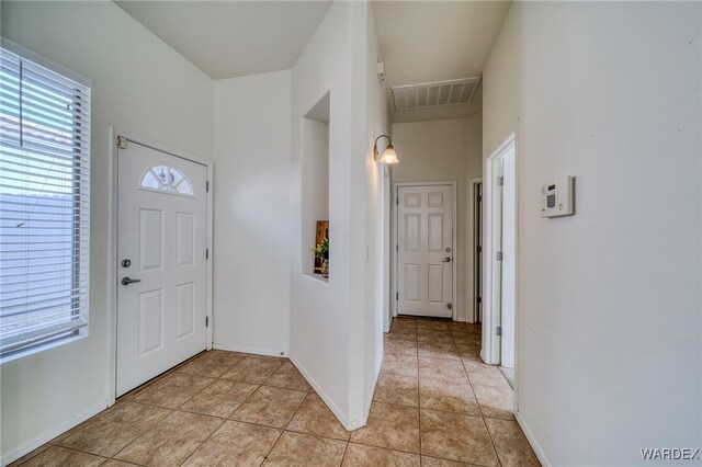 entrance foyer featuring light tile patterned floors, baseboards, and visible vents