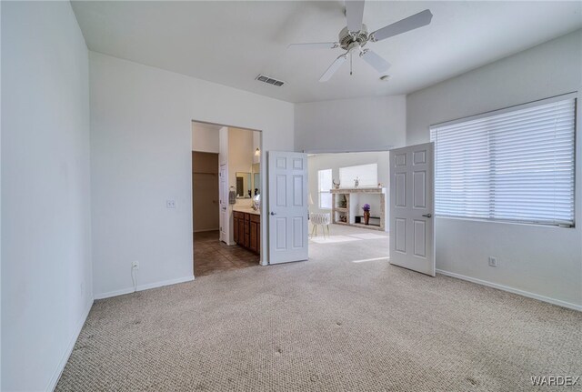 unfurnished bedroom with baseboards, visible vents, and light colored carpet