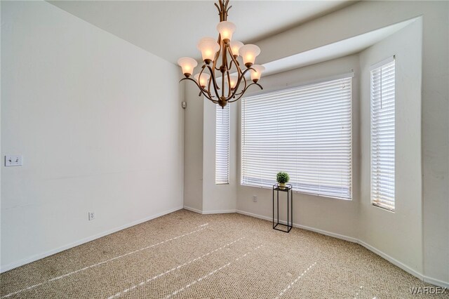 unfurnished room with baseboards, carpet, and a notable chandelier