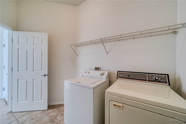 laundry area with light tile patterned floors, laundry area, and washing machine and clothes dryer