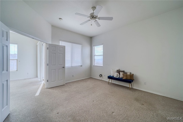 unfurnished bedroom with light carpet, a ceiling fan, and baseboards