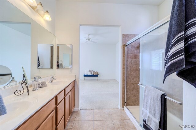 full bathroom featuring double vanity, a stall shower, a sink, ceiling fan, and tile patterned flooring