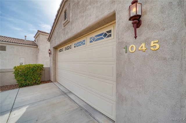 garage featuring concrete driveway