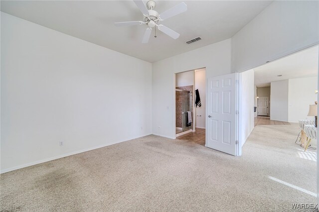 spare room featuring a ceiling fan, light colored carpet, and visible vents